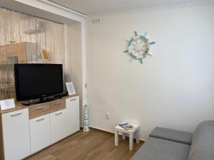 a living room with a couch and a flat screen tv at Mákvirág Apartman in Balatonboglár