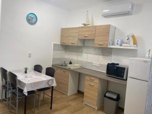 a small kitchen with a table and a refrigerator at Mákvirág Apartman in Balatonboglár