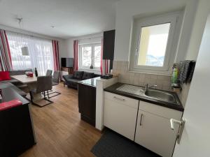 cocina y sala de estar con fregadero y sofá en Haus Alpina Ski In & Ski Out, en Schladming