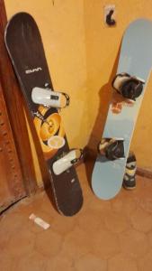 dos tablas de snowboard se inclinan contra una pared en Chez Belkacem en Merzouga