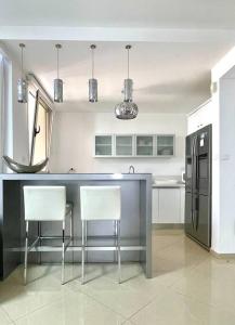 cocina con encimera con 2 sillas y nevera en LOVELY 2BR GOLF RESIDENCE EILAT en Eilat