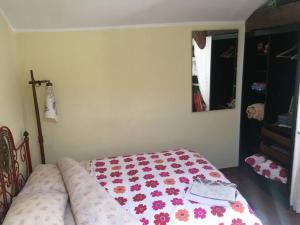 een slaapkamer met een bed met een bloemendeken erop bij A Barraquinha 30 steps from sea in Apúlia