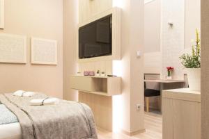 a room with a bed and a television and a desk at Central Relax Boutique Suites in Budapest