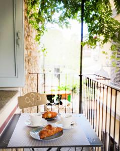 a table with two cups and pastries on a balcony at FWL The Lake Suite in Arona
