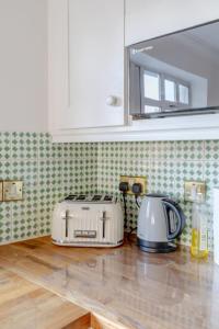 a kitchen counter with a toaster and a toaster and a toaster at Spacious 3BD Flat - 14 Mins to Buckingham Palace! in London