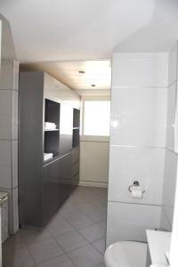 Un baño blanco con inodoro y ventana. en LOVELY 2BR GOLF RESIDENCE EILAT, en Eilat