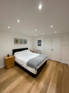 a bedroom with a large bed and a wooden floor at Stunning 3BD Maisonette wBalcony - Old Street! in London