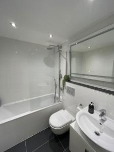 a white bathroom with a toilet and a sink at Stunning 3BD Maisonette wBalcony - Old Street! in London
