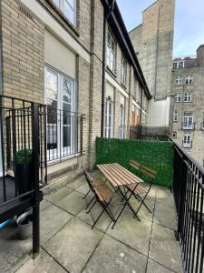 a patio with two chairs and a wooden table at Stunning 3BD Maisonette wBalcony - Old Street! in London