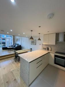 a kitchen with a counter top and a living room at Stunning 3BD Maisonette wBalcony - Old Street! in London