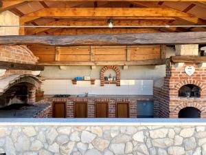 an outdoor kitchen with a stone and wood ceiling at Villa Tovarovica in Primošten