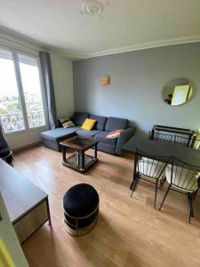 uma sala de estar com um sofá e uma mesa em PARIS- Défense/Puteaux Appartement Cartault em Puteaux