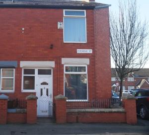 a red brick house with a white door at CHEADLE HOUSE HOLIDAYS in Manchester
