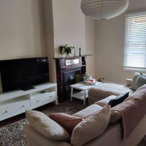 salon z kanapą i telewizorem z płaskim ekranem w obiekcie North Perth Stylish Abode CBD w mieście Perth