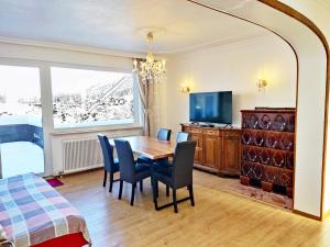 jadalnia ze stołem, krzesłami i telewizorem w obiekcie Aparthotel Pan Haus w mieście Bad Ischl