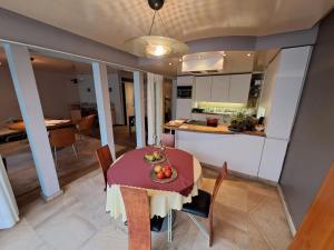 cocina y comedor con mesa y sillas en TRIPLE ROOM met 1 of 2 aparte bedden en extra slaapbank, en Gullegem
