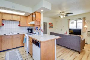 a kitchen with wooden cabinets and a ceiling fan at Cozy Albuquerque Apartment Less Than 1 Mi to Downtown! in Albuquerque