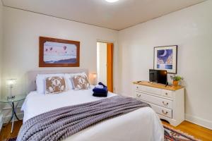 a bedroom with a bed and a dresser with a television at Silver Hill Apartment Near UNM Campus! in Albuquerque