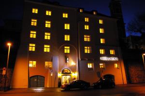 een groot gebouw met 's nachts verlichting bij Hotel König in Passau