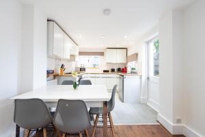 ロンドンにあるBright, Spacious & Large Wimbledon Flat (17WHS)のキッチン(白いテーブル、椅子付)