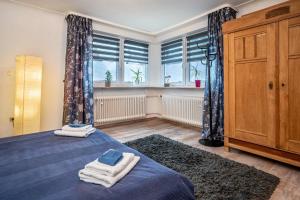 ein Schlafzimmer mit einem blauen Bett und einem Fenster in der Unterkunft Boettcher's Ferienwohnung in Neulußheim