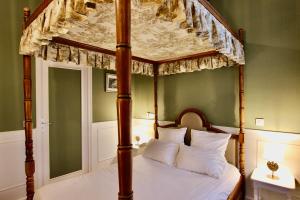 a four poster canopy bed in a green bedroom at Hotel de la Bretonnerie in Paris