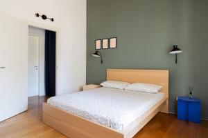 a bedroom with a bed with a wooden headboard at Private Parking, Two Bedrooms & Two Bathrooms - Elegant Apartment in Old Town in Udine