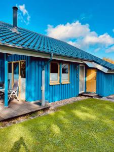 una casa azul con césped delante en Extertal-Ferienpark - Premium Ferienhaus Sauna Wandern #56a en Extertal