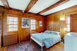 a bedroom with a bed with wooden walls and windows at The Swallow Hill Manor in Franklin