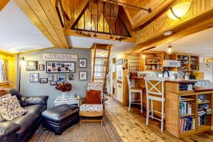 a living room with a leather couch and a kitchen at Sugarloaf Valley Escape in Carrabassett
