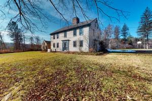 an old white house on a grassy field at The Swallow Hill Manor in Franklin