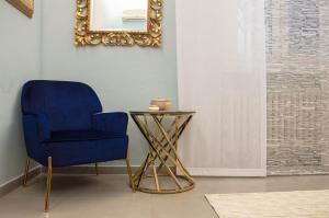 une chaise bleue et une table de chevet dans une pièce dans l'établissement B&B I Tigli sul Navile, à Bologne