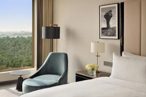a bedroom with a bed and a chair and a window at Al Ahsa InterContinental, an IHG Hotel in Al Ahsa