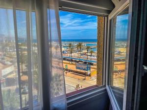 a window with a view of a beach and the ocean at Apartment, Paseo Maritimo 33, Perla 6, Fuengirola, Malaga, Spain. in Fuengirola