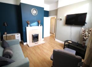 a living room with a couch and a fireplace at Birmingham - Shirley - Large 3 Bed Bungalow - Beautifully Refurbished - Very Large Enclosed Gardens - Off Street Parking - Fast Wifi in Birmingham