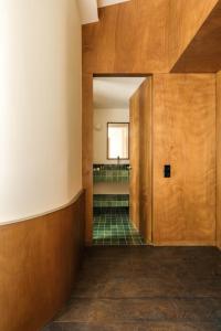 a hallway with a wooden door and green tiles at Edgar Suites - Bouchardon in Paris