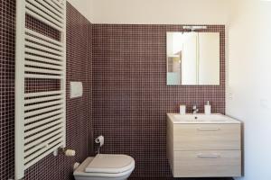 a bathroom with a toilet and a sink and a mirror at Private Parking, Two Bedrooms & Two Bathrooms - Elegant Apartment in Old Town in Udine