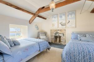 a bedroom with two beds and a fireplace at The Boathouse On The Atlantic Sea in Liscannor