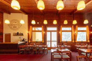 a dining room with tables and chairs and lights at Horská chata Smrekovica in ľubochňa