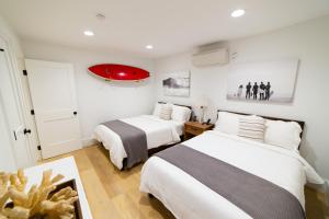 1 dormitorio con 2 camas y luz roja en Newport Surf Casita, en Newport Beach