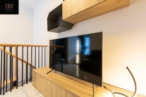 a large flat screen tv hanging on a wall at A lovely duplex maisonette just of Spinola w/WIFI by 360 Estates in St. Julianʼs