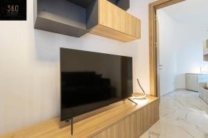 uma grande televisão de ecrã plano pendurada numa parede em A lovely duplex maisonette just of Spinola w/WIFI by 360 Estates em St. Julian's