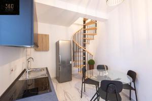 a kitchen with a table and a stainless steel refrigerator at A lovely duplex maisonette just of Spinola w/WIFI by 360 Estates in St. Julianʼs