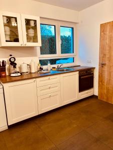 een keuken met witte kasten en een wastafel bij Apartments Maxim in Rust