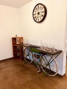 einen Tisch mit Weingläsern und eine Uhr an der Wand in der Unterkunft Apartments Maxim in Rust
