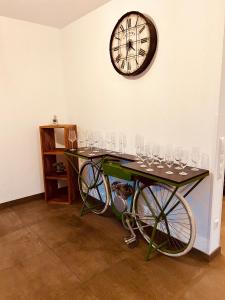 a table with wine glasses and a clock on the wall at Apartments Maxim in Rust