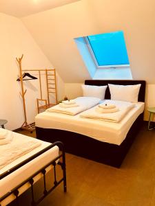 a bedroom with two beds and a skylight at Apartments Maxim in Rust