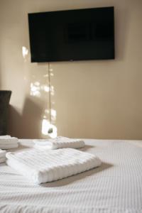 ein weißes Bett mit zwei Handtüchern darüber in der Unterkunft Macao Apartmani in Vinkovci