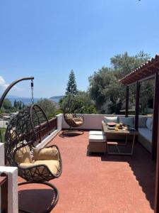 a patio with chairs and a couch and a table at Villa Flower in Skiathos