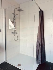 a shower with a shower curtain in a bathroom at Apartments Maxim in Rust